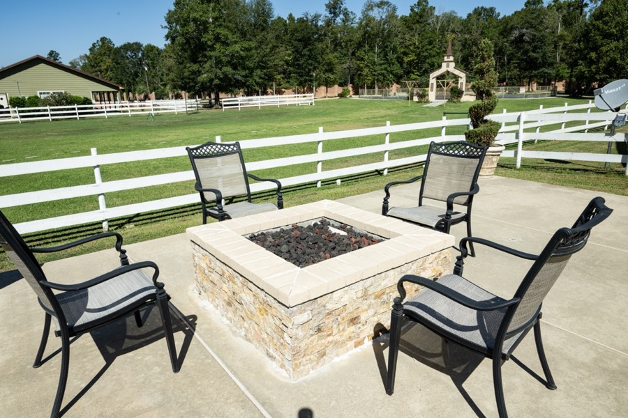 Stone fire pit with seating on the terrace, outdoor chapel visible in the background