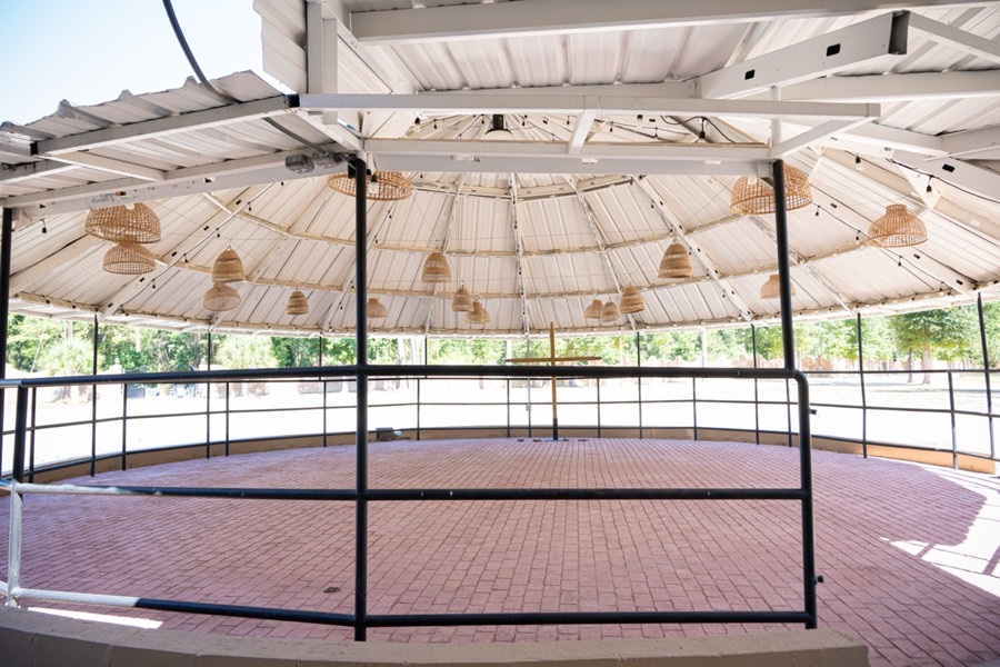 Inspira Ranch round outdoor pavilion with rattan pendant lights and brick herringbone floor