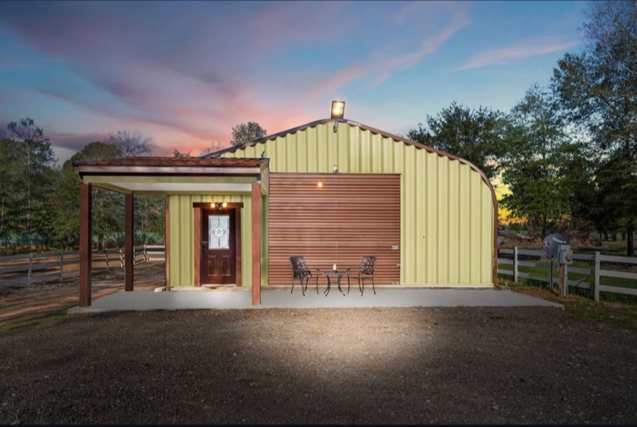 Inspira Ranch private apartment building exterior at dusk with warm interior light and pink sky