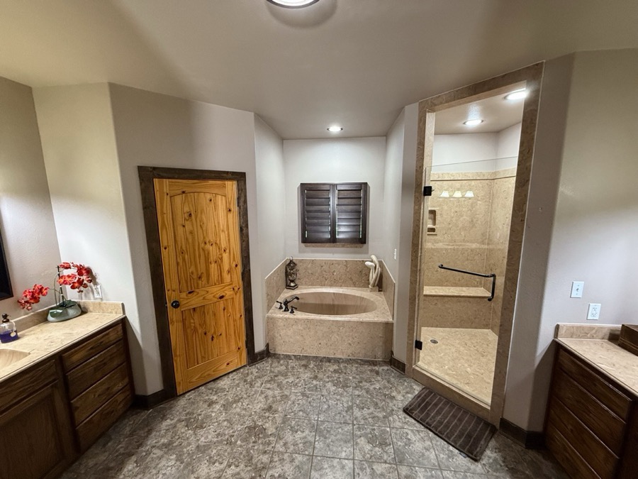Inspira Ranch master bathroom with soaking tub, glass-enclosed shower, and dual vanity
