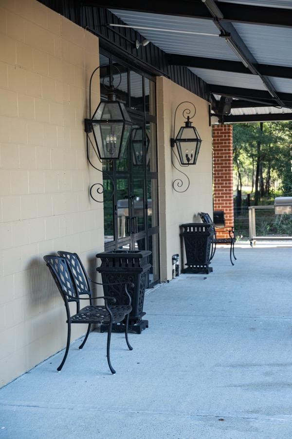Inspira Ranch event hall covered entrance with wrought-iron gas lanterns and patio seating